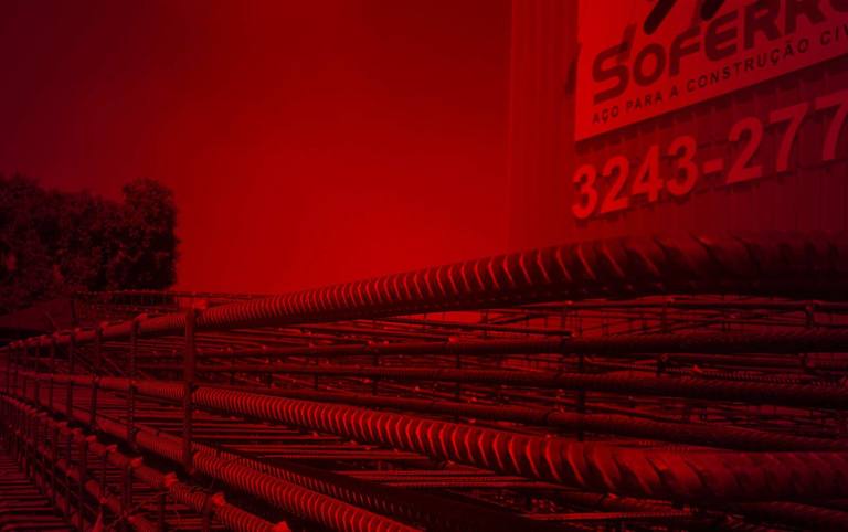 Pátio da Soferro em Biguaçu com vergalhões armazenados e a fachada com o telefone da empresa